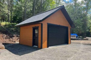 Dalle de béton monolithique. Revêtement extérieur en CanExel et contour de porte et fenêtre en CanExel de 3’’. Soffite de 16’’ et fascia 6’’enaluminiumnoir. Toit cathédral, pente8/12en bardeaux d’asphalte IK0 avec aérateur continu. Porte de garage en aciermodèleUrbain-noir14’ x7’avecmoteurélectrique, isolée R-16. Fenêtre coulissante PVC-noir36’’x 39’’et porte de service en acier-noir34’’ x 82’’avec fenêtre guillotine. Garage Le Standard, 20' x 16' x 8'