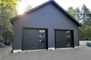 Dalle de béton 6’’ avec contour surélevé de 6’’. Revêtement extérieur en vinyle Gentek avec coin de vinyle. Soffite de 12’’ et fascia de 6’’enaluminiumnoir. Toit habitable avec rangement, pente8/12en bardeaux d’asphalte IK0.2 portes de garage en acier modèle Urbain-noir8’ x 7’ avec4fenêtresà droite incluant un moteur électrique, isolée R-16. Fenêtre coulissante PVC noir36’’x 39’’’etune porte de service en acier noir34’’ x 82’’avec fenêtre fixe 18’’x70’’ givrée. Garage Le Jumeau, 24' x 26' x 9'