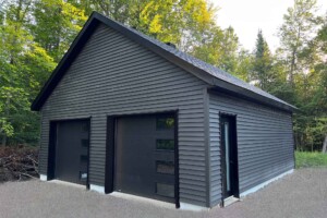 Dalle de béton 6’’ avec contour surélevé de 6’’. Revêtement extérieur en vinyle Gentek avec coin de vinyle. Soffite de 12’’ et fascia de 6’’enaluminiumnoir. Toit habitable avec rangement, pente8/12en bardeaux d’asphalte IK0.2 portes de garage en acier modèle Urbain-noir8’ x 7’ avec4fenêtresà droite incluant un moteur électrique, isolée R-16. Fenêtre coulissante PVC noir36’’x 39’’’etune porte de service en acier noir34’’ x 82’’avec fenêtre fixe 18’’x70’’ givrée. Garage Le Jumeau, 24' x 26' x 9'