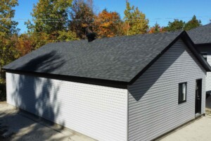 Dalle de béton monolithique .Revêtement extérieur en vinyle Gentek avec coin de vinyle. Soffite de 12’’ et fascia de 6’’en aluminium noir. Toit standard, pente6/12inverséen bardeaux d’asphalte IK0.2 portes de garage en aciermodèlePremium-noir8’ x 7’ avec fenêtres dans le haut, isolée R-16. Fenêtre coulissante PVC noir-36’’x 39’’et une porte de service standard en acier-noir34’’ x 82’’. Garage Le Jumeau, 24' x 36' x 8'