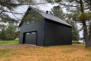 Poutrelle de 16’’ au plancher, muret de 3’ avec toit cathédrale pour un plafond de 11’. Dalle de béton monolithique avec trottoir arrière. Revêtement extérieur en CanExel avec coin et contour de porte et fenêtre en aluminium noir. Soffite de 12’’ et fascia de 6’’ aluminium noir. Toit cathédrale, pente10/12en bardeaux d’asphalte IK0. Porte de garage double en acier modèle Urbain-noir16’ x8’, isolée R-16.Fenêtrea battant aluminium dans la toiture 48’’ x 48’’et au rez-de-chaussée36’’ x 36’’. Une porte de service standard en acier-noir34’’ x 82’’avec panneau de 18’’ x 70’’ vitrée. Garage Le Supérieur, 28' x 30' x 9'