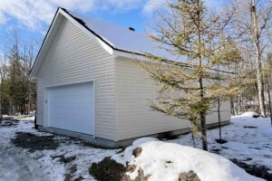 Dalle de béton monolithique.
Revêtement extérieur
en vinyle Gentek
avec coin de vinyle.
Soffite de 12’’ et fascia 6’’ en aluminium blanc. Toiture standard, pente 8/12 en bardeaux d’asphalte IK0. Porte de garage
en acier double modèle Premium (4 colonnes x 4 rangées)
- blanc 16’ x 7’, isolée R - 16.
Fenêtre coulissante PVC - blanc 36’’ x 39’’ et une porte de service standard
en acier - blanc 34’’ x 82’’. Garage Le Standard, 24' x 30' x 9'